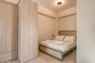 a bedroom with a bed with white sheets at Vissalo Studios in Kissamos