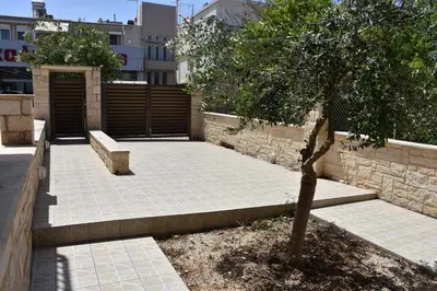 a park with a bench and a tree and a building at Stefanie's House in Chania Town