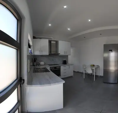 a kitchen with white cabinets and a counter top at Stefanie's House in Chania Town
