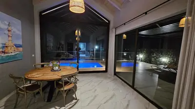a dining room with a table and a large glass window at Fiorella Sea View Pool Villa in Kalyves, Chania area, Crete in Kalyves