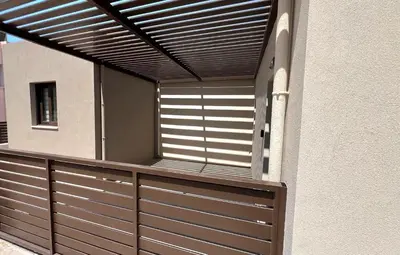 a house with a garage door with a wooden fence at Fiorella Sea View Pool Villa in Kalyves, Chania area, Crete in Kalyves