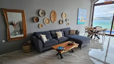 a living room with a blue couch and a table at Fiorella Sea View Pool Villa in Kalyves, Chania area, Crete in Kalyves