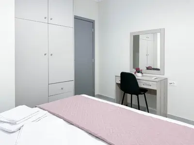 a bedroom with a bed and a desk and a chair at All Seasons Luxury Apartment in Chania Town