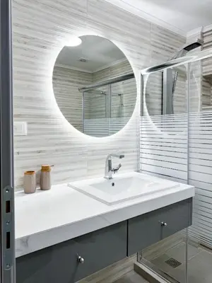 a white bathroom with a sink and a mirror at All Seasons Luxury Apartment in Chania Town