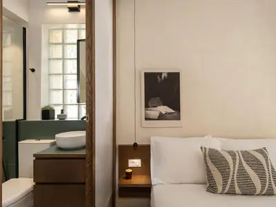 a bedroom with a bed and a bathroom with a sink at Green Lilly Home in Chania Town