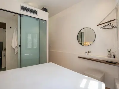 a bedroom with a white bed and a mirror at Green Lilly Home in Chania Town