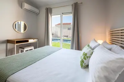 a bedroom with a white bed and a window at Peponas Residence in Kato Daratso
