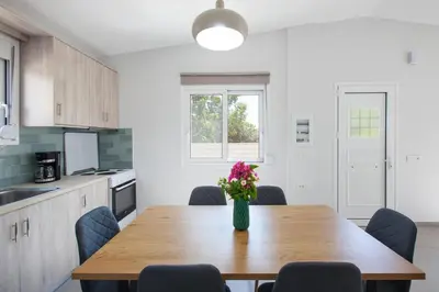 a kitchen with a wooden table with a vase of flowers on it at Peponas Residence in Kato Daratso