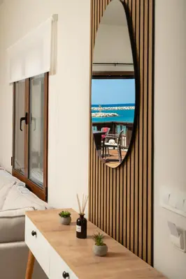 a bedroom with a mirror and a bed and a table at Ekati Seaside Living in Kolymvari