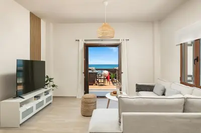 a living room with a couch and a tv at Ekati Seaside Living in Kolymvari