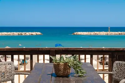 a wooden table with a potted plant on the beach at Ekati Seaside Living in Kolymvari