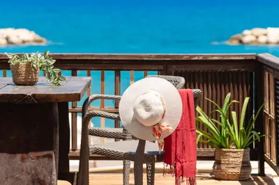 a hat and a red towel sitting on a chair at Ekati Seaside Living in Kolymvari