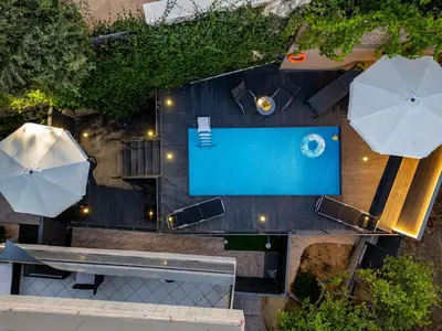 an overhead view of a pool with a bench and umbrella at Blissful Residence with Pool by 8essentially in Daratso