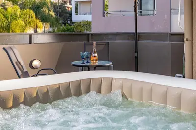 a bath tub with water in it with a table at Panorama View Apt with Jacuzzi by 8essentially in Daratso