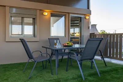 a table and chairs on a patio with grass at Panorama View Apt with Jacuzzi by 8essentially in Daratso