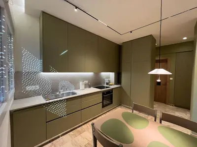 a kitchen with green cabinets and a table and chairs at Kia's city retreat in Chania Town