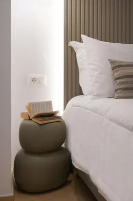 a bed with a book on a ottoman next to a bed at Porta Harenae Residencia in Chania Town