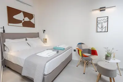 a bedroom with a bed and a table and a chair at Comfinest in Chania Town