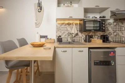 a kitchen with a wooden table and a counter top at Comfinest in Chania Town