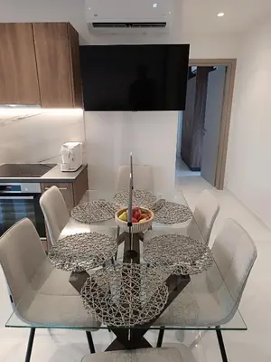 a dining room table with chairs and a bowl of fruit on it at The Athena Apartment, Chania Seaside in Chania Town