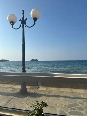 a street light sitting next to the ocean at The Athena Apartment, Chania Seaside in Chania Town