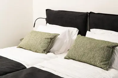 a bed with white sheets and green pillows at Paradise Hill Luxury Villa in Kalyves