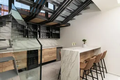 a kitchen with a counter and a bar with stools at Paradise Hill Luxury Villa in Kalyves