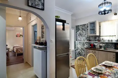 a kitchen and dining room with a table and a refrigerator at Favola Golden Beach Villa in Daratso