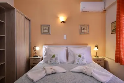 a bedroom with a bed with two slippers on it at Favola Golden Beach Villa in Daratso
