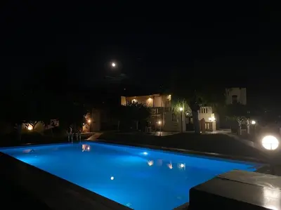 a large blue swimming pool at night at Villa Marianna Lygides in Ayiá