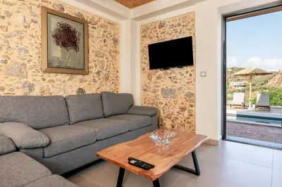 a living room with a couch and a table at Villa Elpida in Myloniana in Milonianá