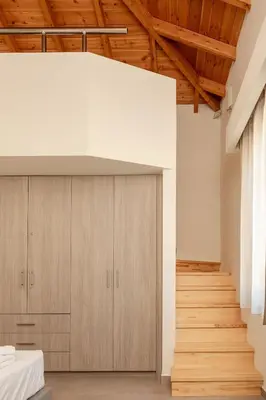 a room with wooden cabinets and a staircase at Villa Elpida in Myloniana in Milonianá