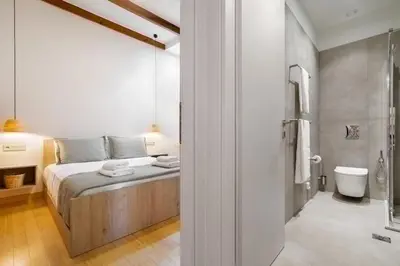 a bedroom with a bed and a bathroom with a shower at Leo Apartment 2 bdr apt overlooking the harbor in Chania Town