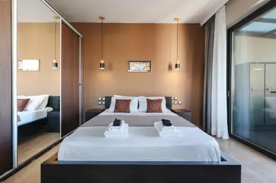 a bedroom with a large white bed with two towels at Villa Cicada Chania, steps from the beach, Car included in Agia Marina Nea Kydonias