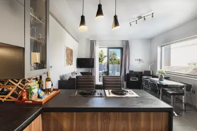 a kitchen and living room with a counter and a table at Villa Cicada Chania, steps from the beach, Car included in Agia Marina Nea Kydonias