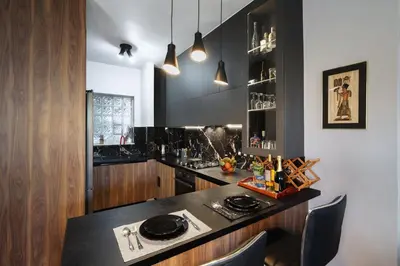 a kitchen with a black counter and wooden cabinets at Villa Cicada Chania, steps from the beach, Car included in Agia Marina Nea Kydonias