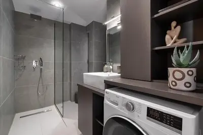a bathroom with a washing machine and a sink at Comfy Apt terrace and parking 800m to old town and beach in Chania Town