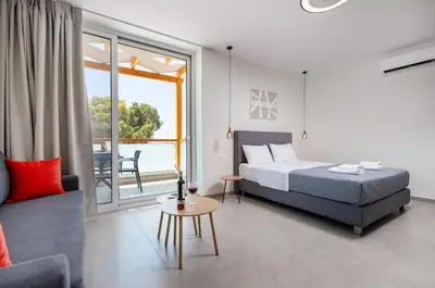 a bedroom with a bed and a couch and a window at Meli apartments Paleochora in Palaiochóra