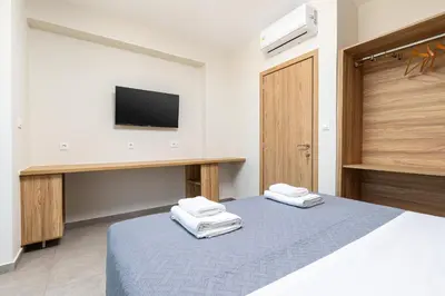 a bedroom with a bed with a tv on the wall at Meli apartments Paleochora in Palaiochóra