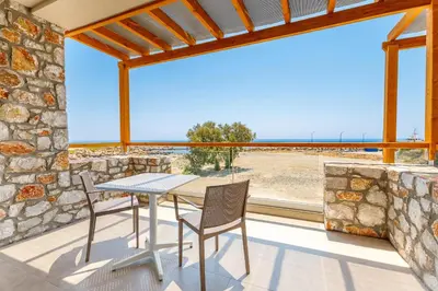 a table and chairs on a balcony with a view of the ocean at Meli apartments Paleochora in Palaiochóra