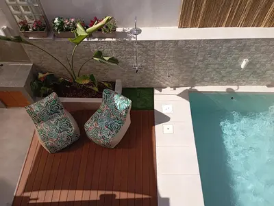 a swimming pool with two pillows next to a wooden deck at Luxious Holiday Apt in Chania Town
