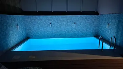 a large swimming pool with blue lighting in a room at Luxious Holiday Apt in Chania Town
