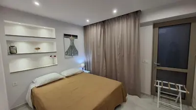 a bedroom with a bed and a window and a chair at Luxious Holiday Apt in Chania Town