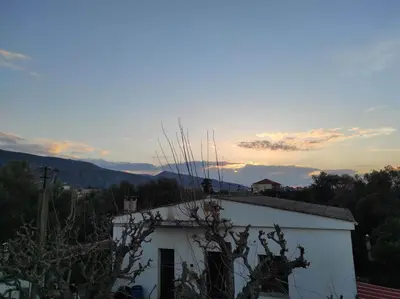 a white building with the sunset in the background at Natura Calma - Private Estate in Chania Town