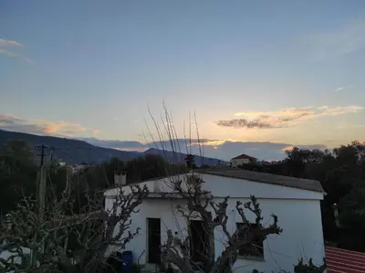 a white building with the sunset in the background at Natura Calma - Private Estate in Chania Town