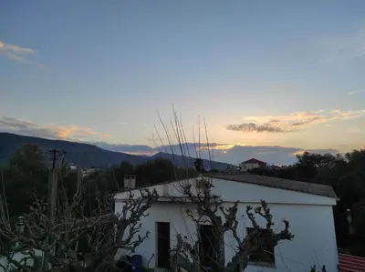 a white building with the sunset in the background at Natura Calma - Private Estate in Chania Town