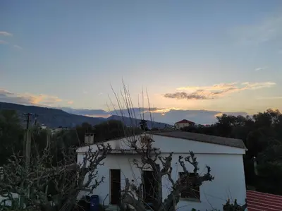a white building with the sunset in the background at Natura Calma - Private Estate in Chania Town