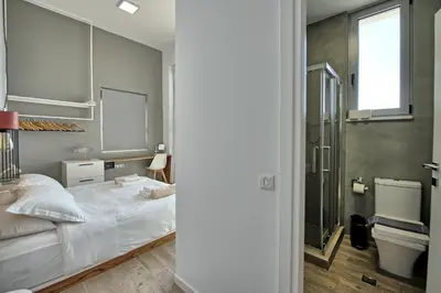 a bedroom with a white bed and a window at Villa Sapphire by PosarelliVillas in Almirida