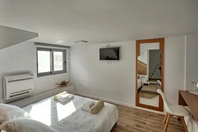 a white room with a bed and a mirror at Villa Sapphire by PosarelliVillas in Almirida