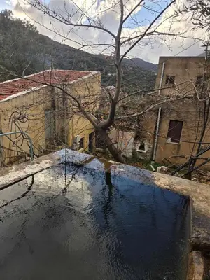 a pool of water in front of a building at Κρητικό Σπίτι Στον Παράδεισο in Palaiochóra